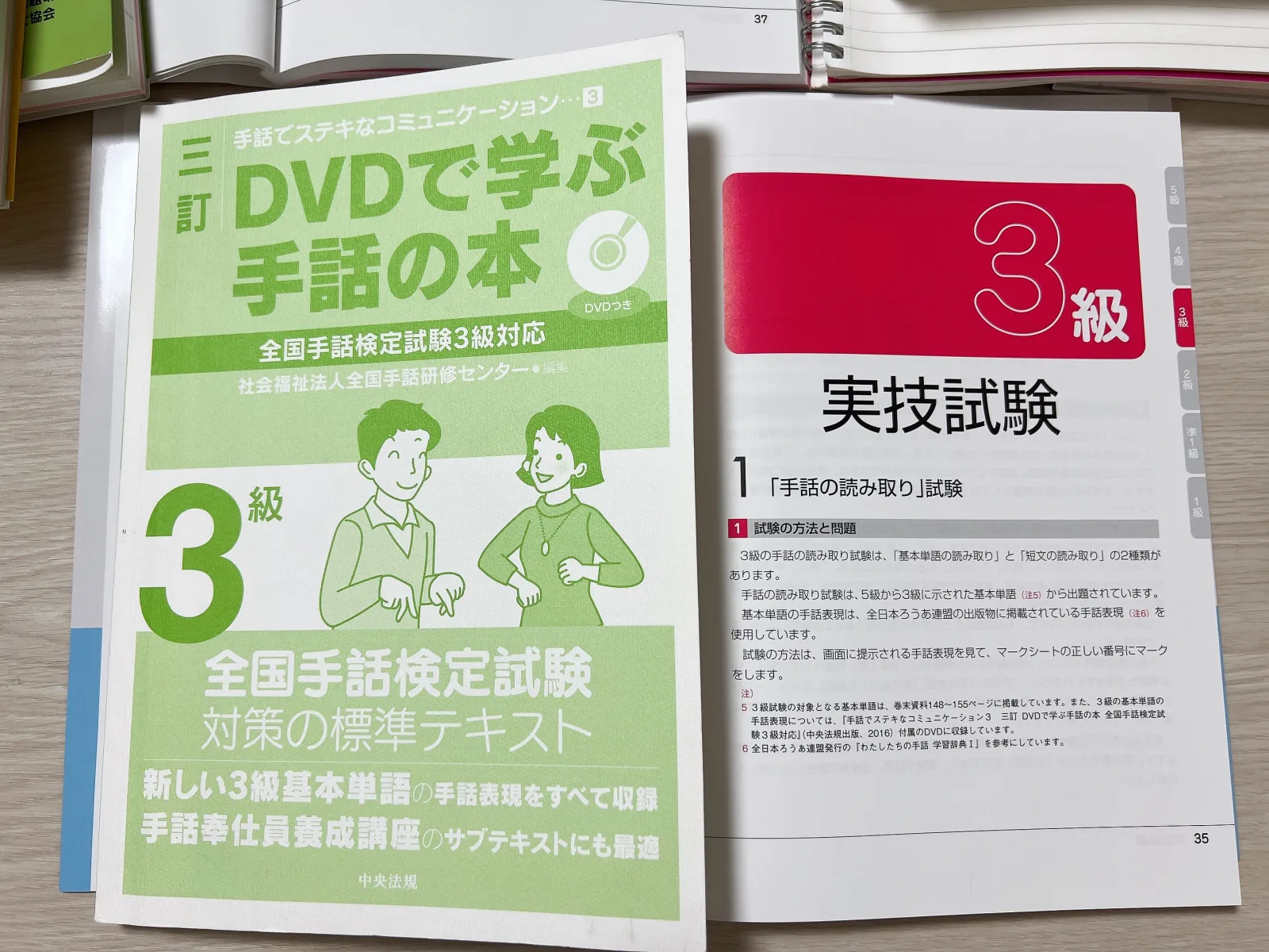 全国手話検定3級の標準テキストと読み取り試験のページを並べた写真