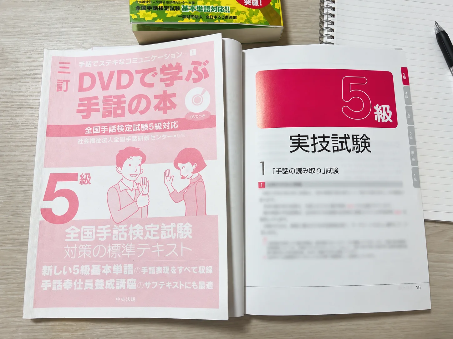 全国手話検定5級の標準テキストと過去問題集を開いた写真