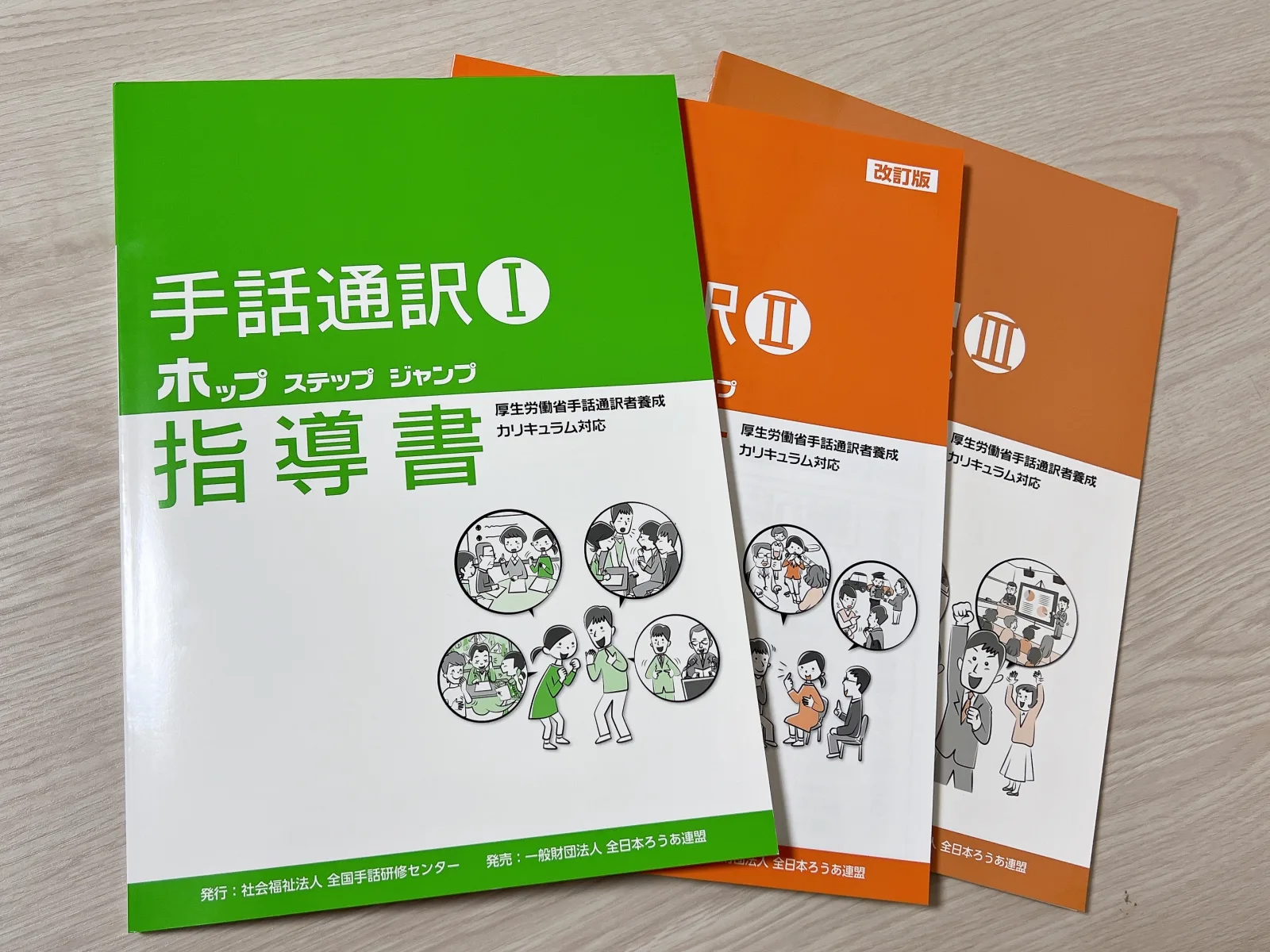 手話通訳I・II・III ホップ ステップ ジャンプの指導書を並べた写真