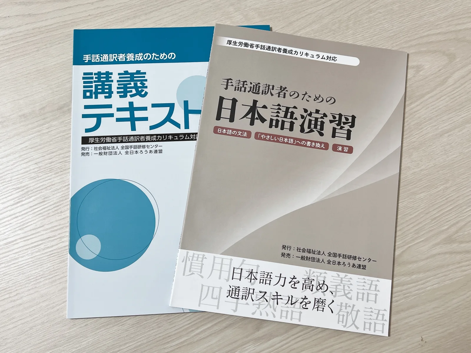 手話通訳者養成のための講義テキストと手話通訳者のための日本語演習を並べた写真