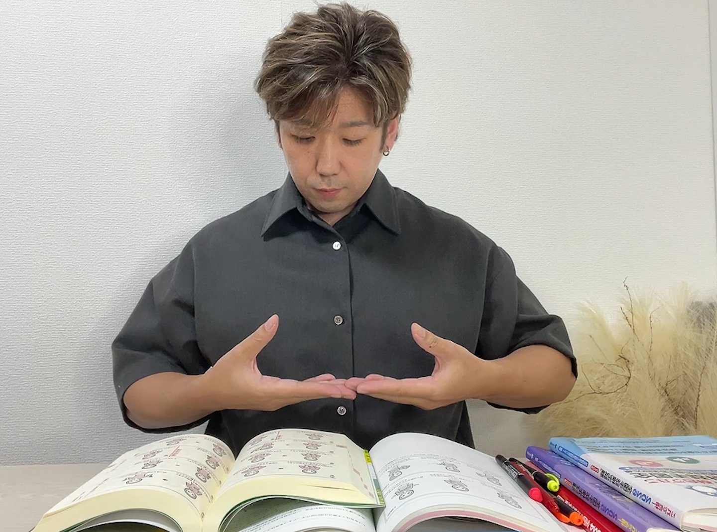 辞書や教材を開き、手話表現を確認している筆者