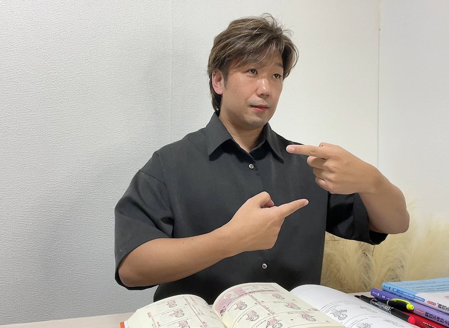 教材で確認した表現を実際に手話で練習している筆者
